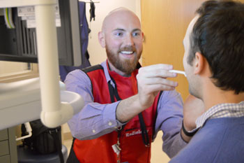 Nick Bollinger works with a patient on a swallow test.