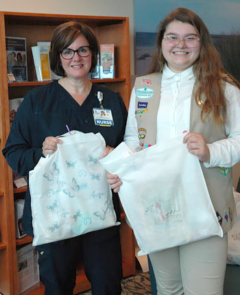 Lisa Henderson, RN, OCN, Oncology Nursing Manager at Beebe Healthcare’s Tunnell Cancer Center accepts “Hope Bags” from local Girl Scout Mickayla Austin. 
