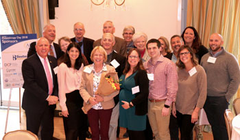 Shown is Judy Aliquo, center, at the awards ceremony surrounded by colleagues, friends and family. Shown in front (left to right) are Tom Protack, Vice President of Development, Beebe Medical Foundation; Tina DiSabatino, Alumni Director for Wilmington Fri