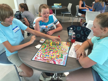 Ainsley Bell, Keelie Conaway, and Makeni Whaley practice playing board games on their lunch break.