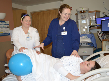 A mother uses a peanut ball to ease labor.