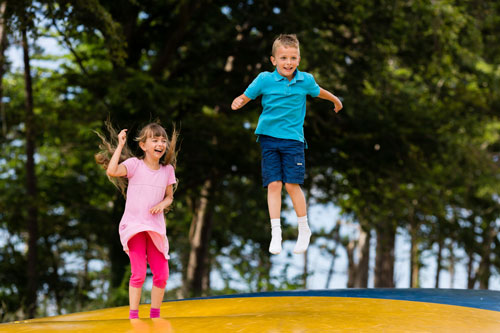 Kids bouncing on inflated pillow.