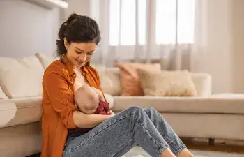 Mother breastfeeding her baby at home