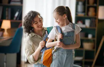 Mother helping her daughter get ready for school