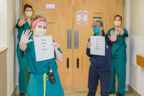 In the front holding signs from left to right is Mallory Drew and on the right is Bobbie Hensey. In the back left to right is Gabi Fazio and Katrina Sellers.