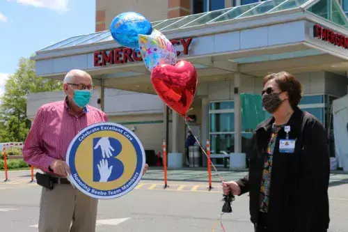 Ed Gilpin celebrates the excellent care his wife, Lois, received at Beebe along with his friend Catherine Walls, Beebe Healthcare’s Patient Experience Program coordinator.