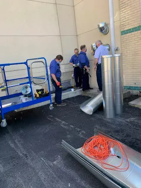 Eric Vent, Terry Donovan, Bob Thompson, and Tom Ohara installing 2000 CFM HEPA filtration negative pressure units in preparation of the surge.