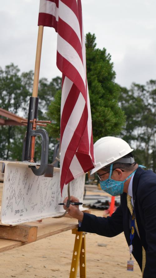 Dr. David Tam signs beam at Specialty Surgical Hospital topping out ceremony.