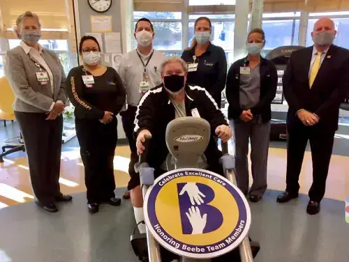 Celebrating Pete Harrigan’s donation to cover the cost of a new NuStep machine at Beebe’s Pulmonary Rehabilitation Program are (l-r) Kay Young, Cindy Blemle, Chris Steele, Kelly Thompson, Cindy Adkins and Tom Protack, with Harrigan on the machine in front.
