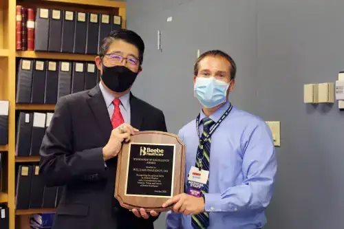 Chasanov_Tam.jpg Dr. David Tam, President and CEO of Beebe Healthcare, giving the Standards of Excellence Award to Dr. Bill Chasanov.