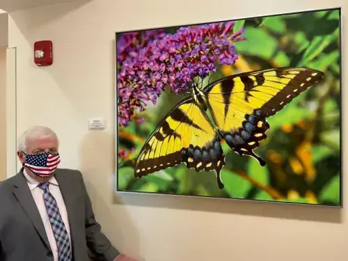 Ken Smith stands by the art he sponsored at Beebe’s new South Coastal Cancer Center in memory of his wife. The plaque reads “Yellow Swallowtail by Ron Bojarski Sponsored by Kenneth P. Smith in Memory of Denise Michele Smith, Loving Wife and Mother.”