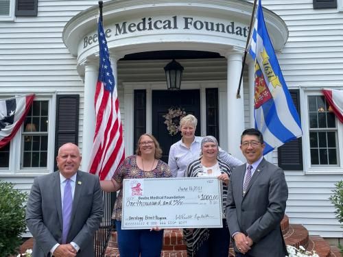 Tom Protack, President of Beebe Medical Foundation, Kay Young, Executive Director of Development, and Dr. David Tam, President and CEO of Beebe Healthcare receive the Paws for a Cause gift from Jenn Parnell and Lynn Wilkins.