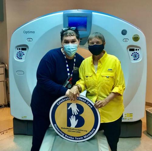 Mary Jo Cauley, left, is shown with grateful patient Kim King in front of the CT scan at Beebe