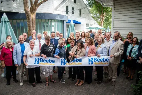 Rebecca Marcinak cuts the ribbon with those in attendance.